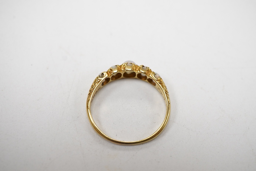 A late Victorian yellow metal and five stone graduated white opal set half hoop ring, the inner shank engraved 'Bran? Ap 4.89', size L.